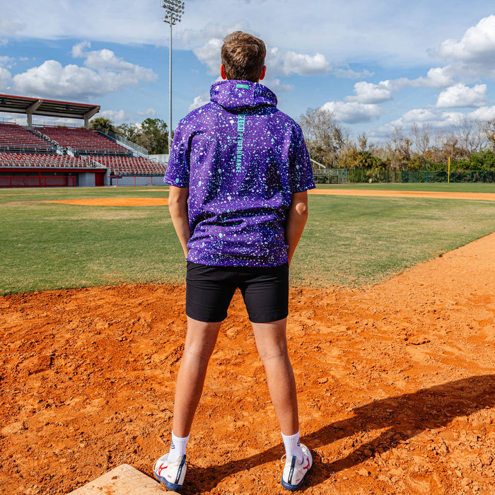 Adult model wearing splatter purple and teal BSBL-SZN short sleeve hoodie