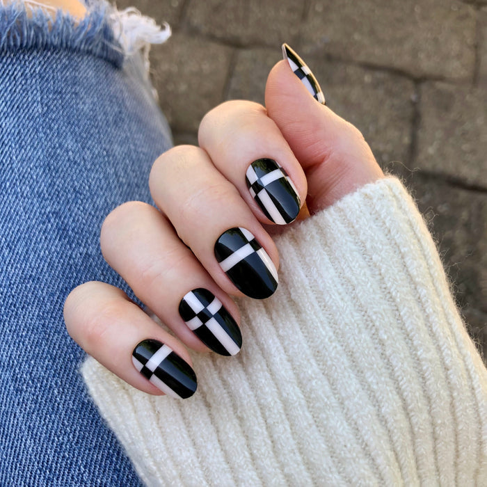 Geometric Plaid | Medium | Oval - Tab Press-On showing black oval nails with white plaid design for easy at home manicure