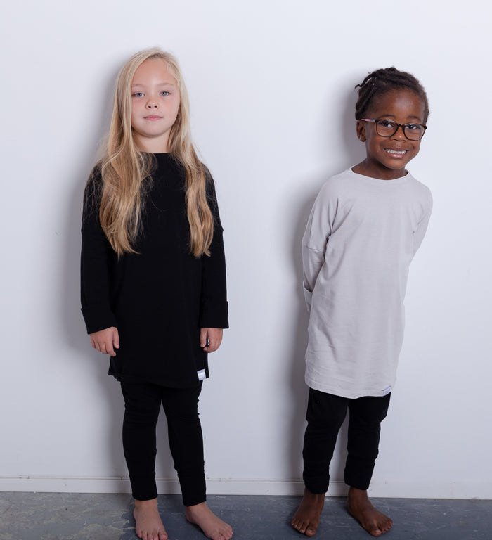 Black grow-with-me shirt for toddlers and kids, designed to be worn as a dress, tunic, or long shirt. Seamless shoulders and soft, eco-friendly fabric. Ethically made in Canada.