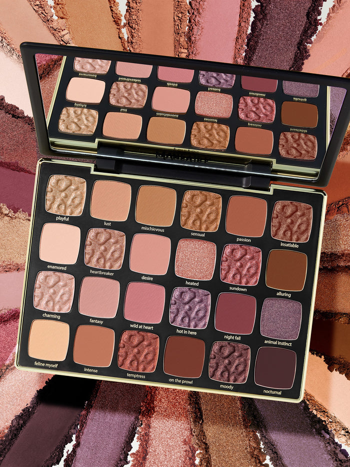 Makeup palette with various shades of eyeshadows on a colorful background