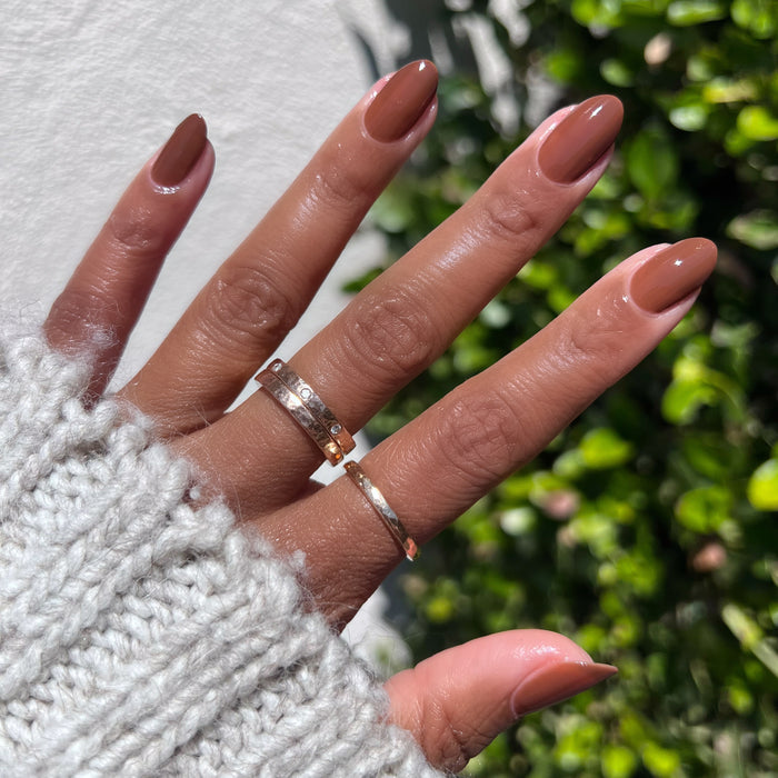 Hand with Americano gel polish in a rich coffee brown shade for a smooth, long-lasting at home manicure look