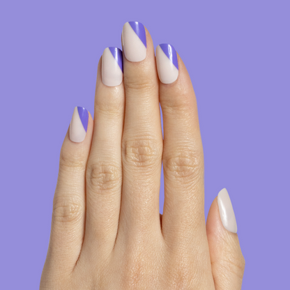 Asymmetrical French | Short | Squoval - Tab Press-On nails with indigo diagonal tips on natural base on hand against purple background
