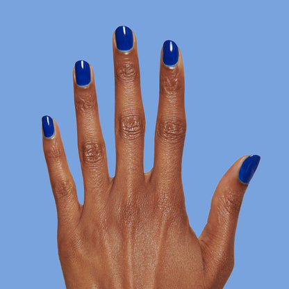 Blueberry Muffin cobalt blue long-lasting polish on natural nails shown against soft blue background