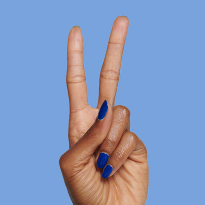 Blueberry Muffin cobalt blue long-lasting polish on almond-shaped nails against a solid blue background