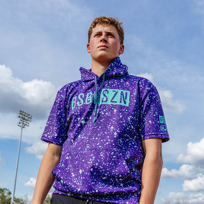 Adult model wearing splatter purple and teal BSBL-SZN short sleeve hoodie