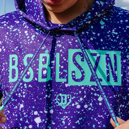 Adult model wearing splatter purple and teal BSBL-SZN short sleeve hoodie