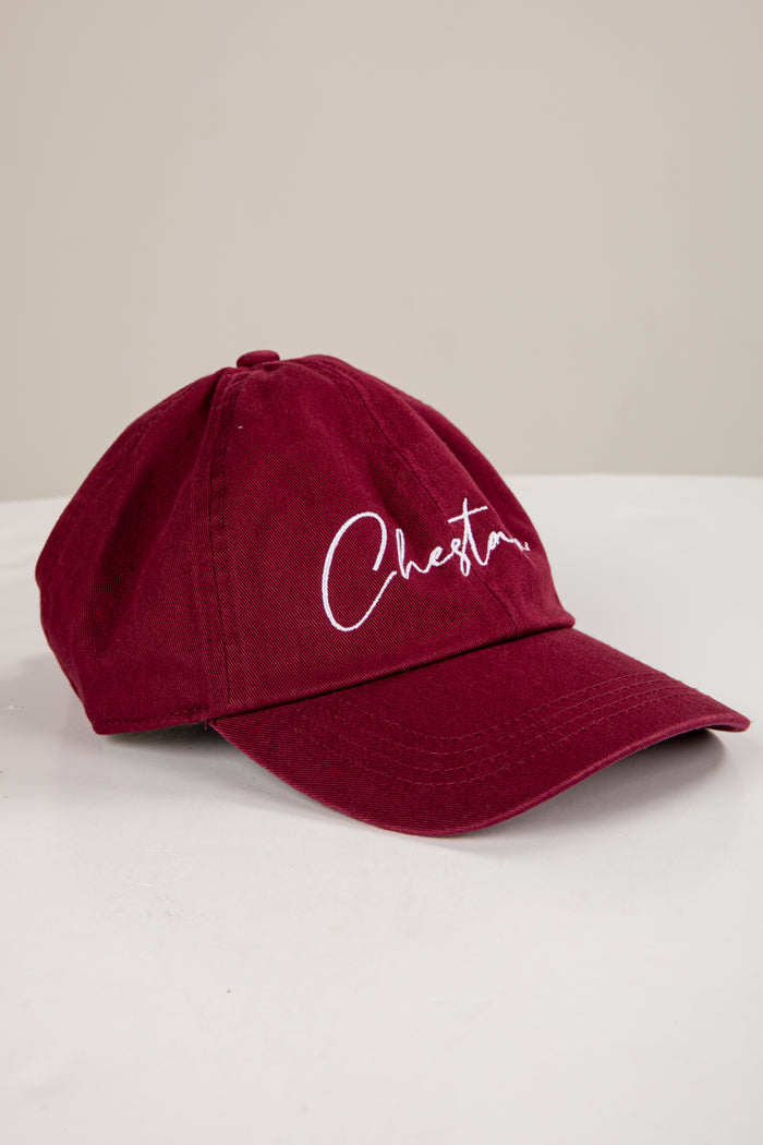 Maroon cap with 'Chester' embroidered on a white surface