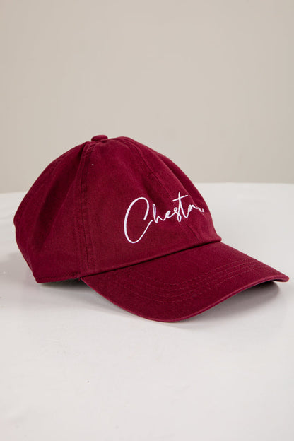 Maroon cap with 'Chester' embroidered on a white surface