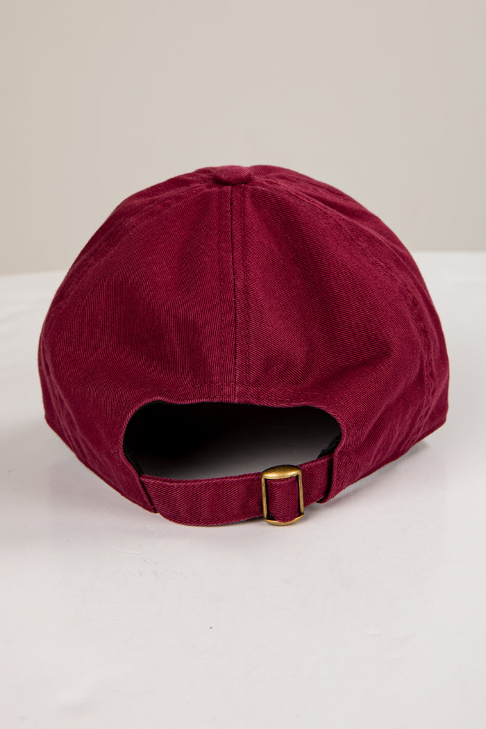 Maroon cap with a gold buckle on a white background
