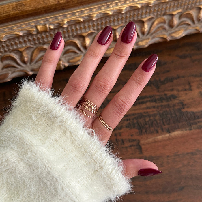 Cabernet | Medium | Oval - Tab Press-On showing glossy medium oval dark plummy red press-on nails for easy at home manicure