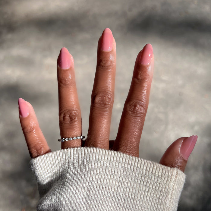 Hand with warm brown skin wearing Can I Borrow A Sweater? glossy gel polish manicure in natural sunlight