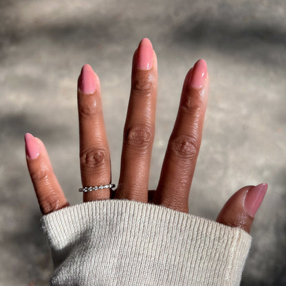 Hand with warm brown skin wearing Can I Borrow A Sweater? glossy gel polish manicure in natural sunlight
