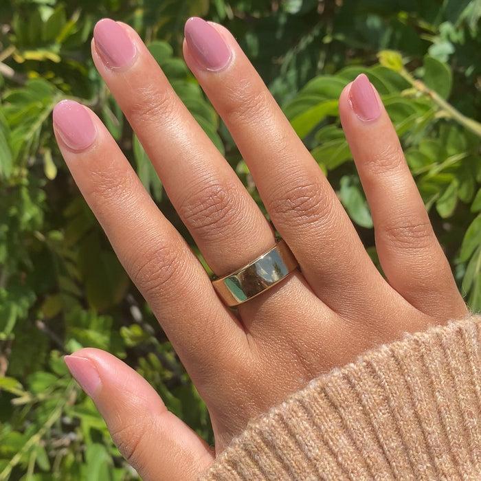Hand with medium warm skin tone wearing Can I Borrow A Sweater? gel polish manicure outdoors with cozy sweater sleeve