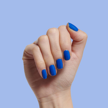 Hand with medium-length nails painted in bright jersey blue Can’t Lose for a smooth, long-lasting manicure by Olive and June