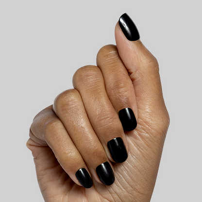 Cateye | Extra Short | Squoval - Tab Press-On nails in glossy deep black shown on hand with natural skin tone
