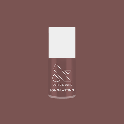 Bottle of Olive and June Clocking Out Early long-lasting gel polish in neutral minky brown shade on matching background