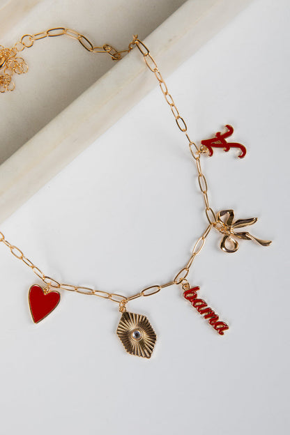 Gold bracelet with various charms including a red heart, leaf, and 'Roma' word on a white background