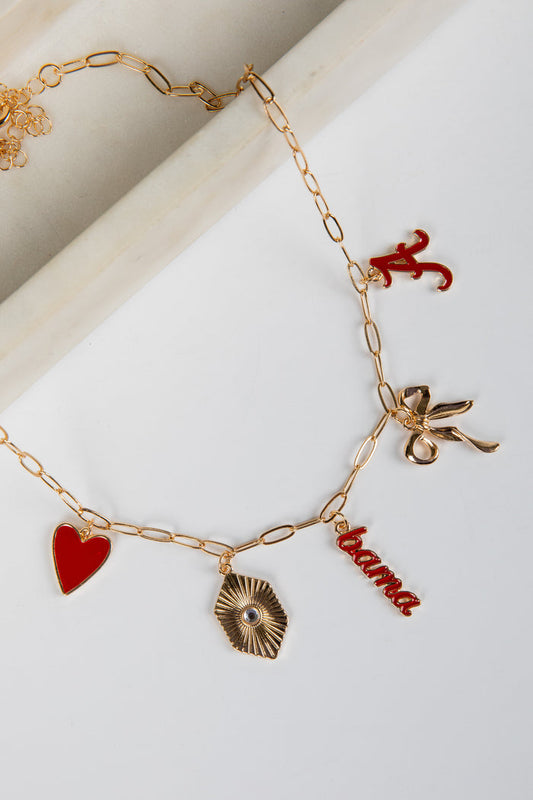 Gold bracelet with various charms including a red heart, leaf, and 'Roma' word on a white background