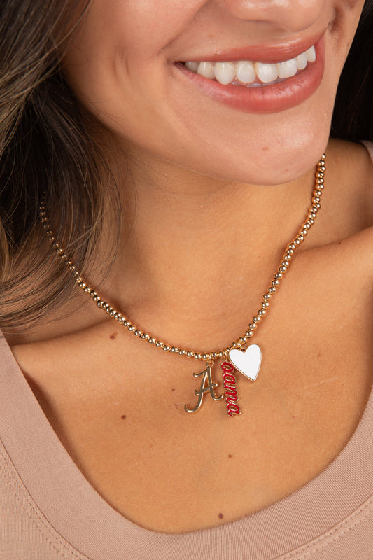 Close-up of a woman wearing a gold necklace with charms.