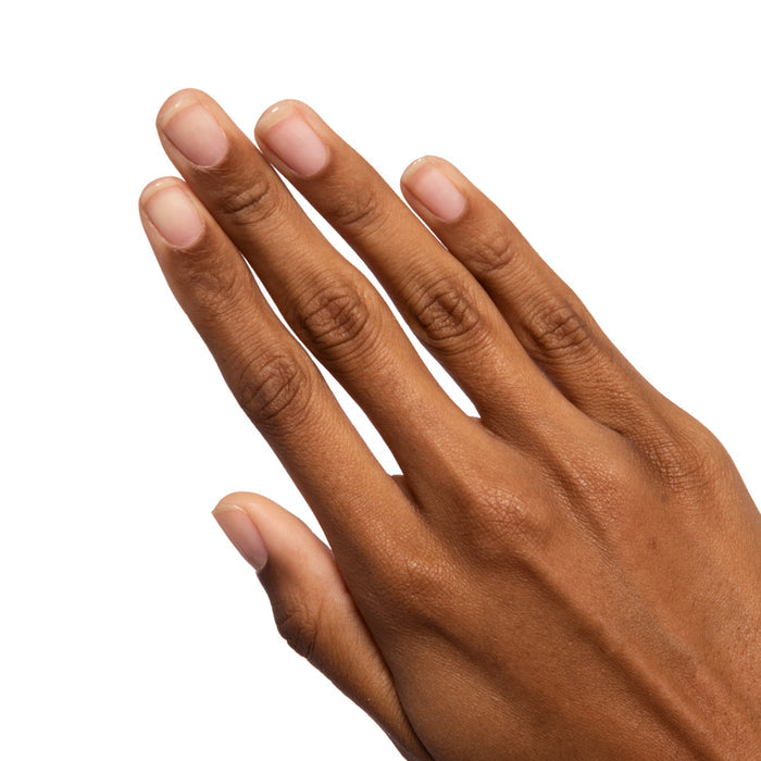 Hand displaying natural nails with Crystal clear glossy polish for a bright and effortless manicure look