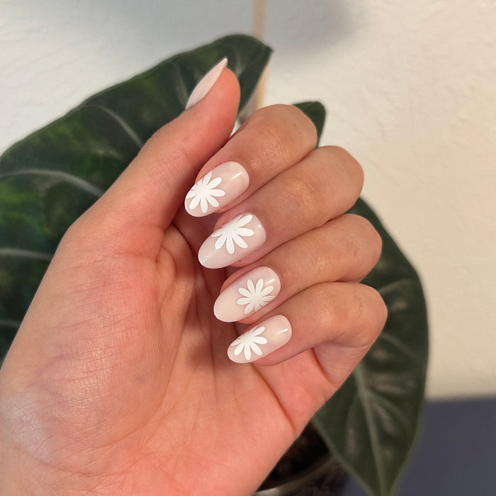 Daisy Pop | Medium | Oval - Tab Press-On showing neutral medium oval press-on nails with large white daisy designs for an easy mani