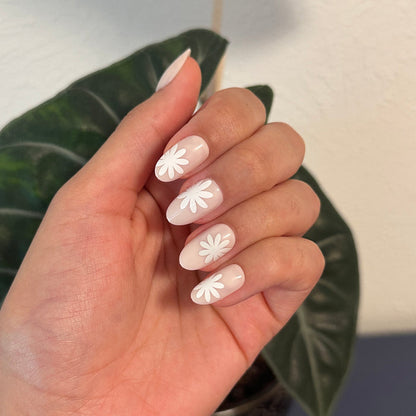 Daisy Pop | Medium | Oval - Tab Press-On showing neutral medium oval press-on nails with large white daisy designs for an easy mani