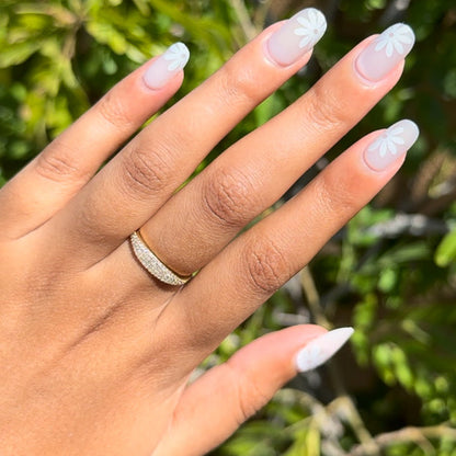 Daisy Pop | Short | Round - Tab Press-On nails with soft matte finish and white daisy petals on natural nails outdoors