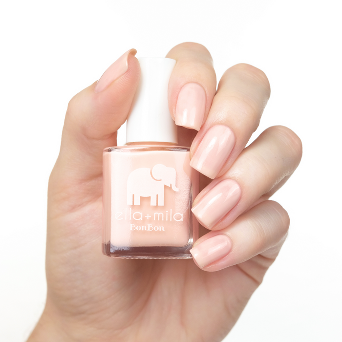 Dessert Island soft nude nail polish manicure on a light skin tone with the bottle