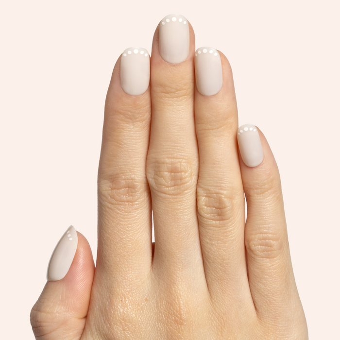 Dotted French | Short | Round - Tab Press-On showing short round neutral press-on nails with white dot French tip design on hand