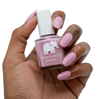 Dulce Amor dusty rose nail polish on a deep skin tone, hand holding the bottle