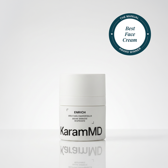 A white cylindrical jar of KaramMD Enrich Breathable Barrier Balm on a light gray reflective surface, with a dark teal circular award badge in the top right reading 'The Manual Best Face Cream Award Winner'.