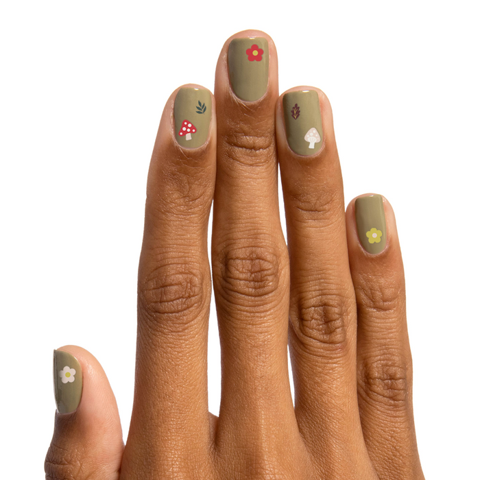 Fall Elements nail art stickers with mushrooms, flowers, and leaves applied on muted green manicure nails