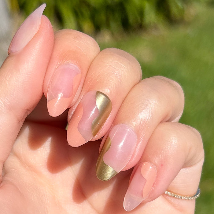 Fall Groovy Swirl - Press-On | Medium | Almond false nails with peach and gold swirl design in natural light outdoors