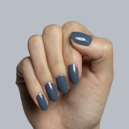 Hand with light skin tone wearing glossy Favorite Beanie gel polish manicure against soft grey background