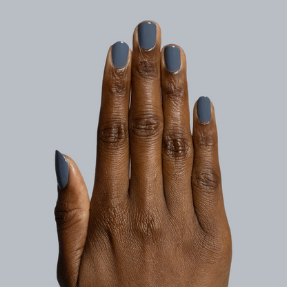 Hand with dark skin tone wearing Favorite Beanie gel polish manicure in deep slate grey on grey background