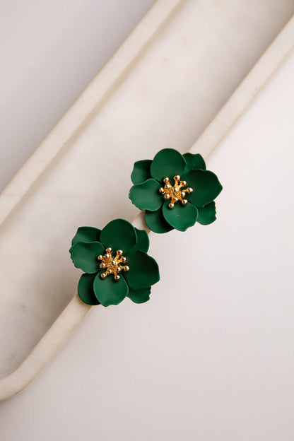Green floral earrings with gold centers on a light background