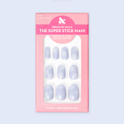 Floral Doodle | Short | Round - Tab Press-On nails in pastel blue with white floral doodles displayed in retail packaging