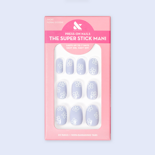 Floral Doodle | Short | Round - Tab Press-On nails in pastel blue with white floral doodles displayed in retail packaging