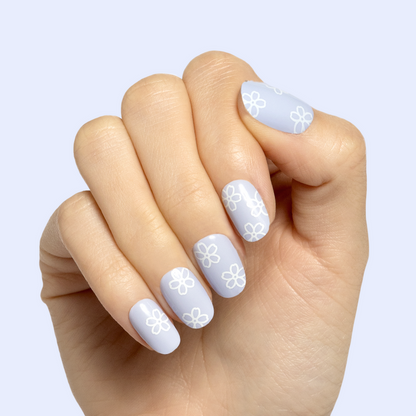 Floral Doodle | Short | Round - Tab Press-On nails with pastel blue base and white flower doodles on hand against light background