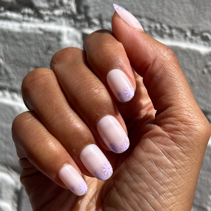 Floral Tip | Short | Round - Tab Press-On nails with soft neutral base and subtle lavender floral design on tips shown on hand