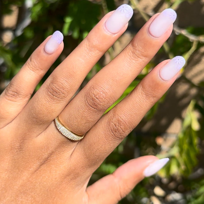 Floral Tip | Short | Round - Tab Press-On nails with soft neutral base and delicate lavender floral tips on hand outdoors in sunlight