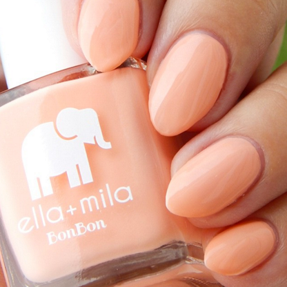 French Kiss peachy coral nail polish close-up with the bottle