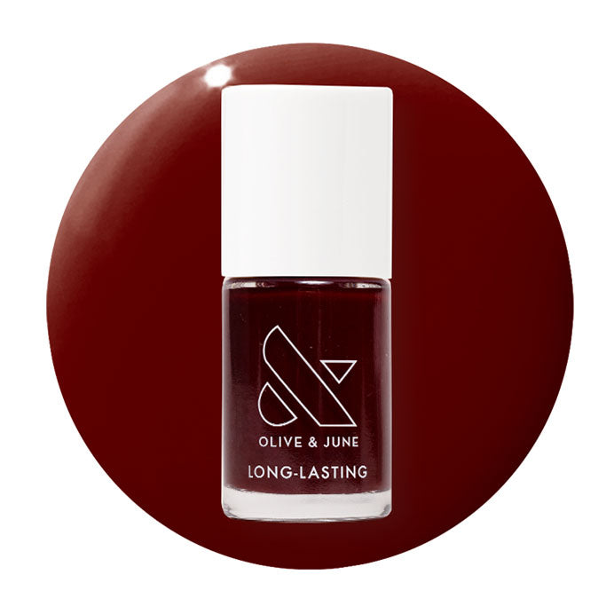 Olive & June Garnet Glass nail polish bottle with deep scarlet gel polish on white cap against matching red background