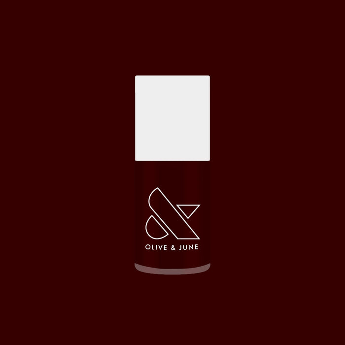 Garnet Glass nail polish bottle with deep scarlet gel color against a rich dark red background