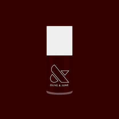 Garnet Glass nail polish bottle with deep scarlet gel color against a rich dark red background