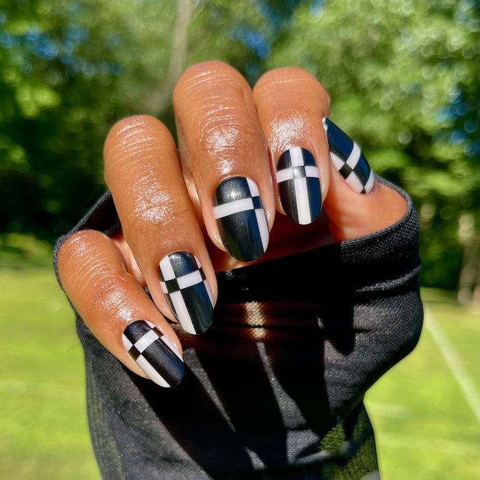 Geometric Plaid | Medium | Oval - Tab Press-On showing medium oval black nails with bold white geometric plaid design for easy at home mani