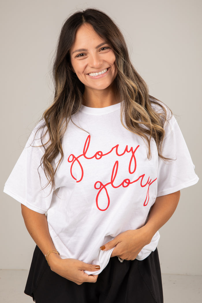 Woman wearing a white t-shirt with 'glory glory' in red text against a plain background