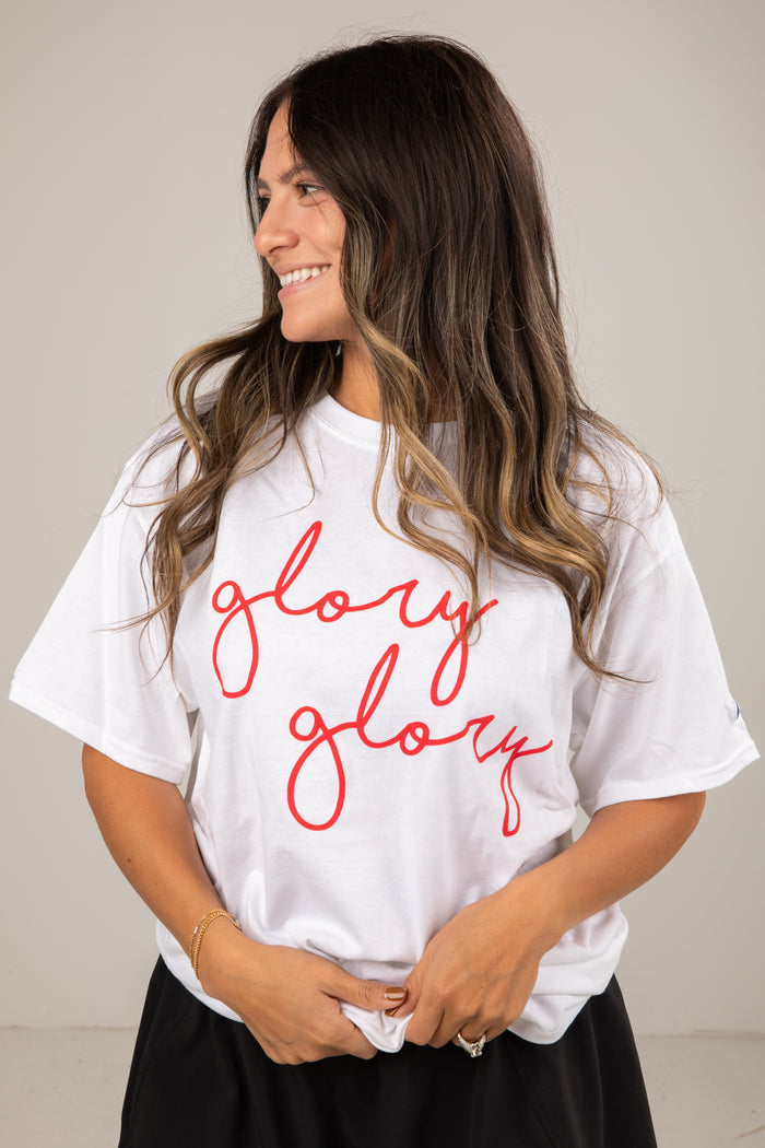 Woman wearing a white t-shirt with 'glory glory' in red text against a plain background