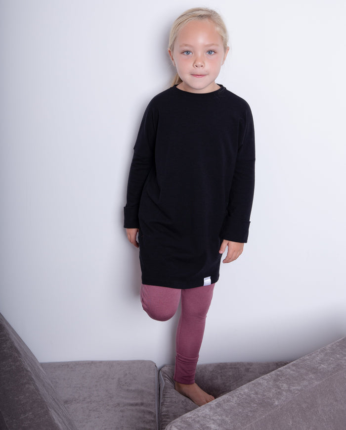 Black grow-with-me shirt for toddlers and kids, designed to be worn as a dress, tunic, or long shirt. Seamless shoulders and soft, eco-friendly fabric. Ethically made in Canada.