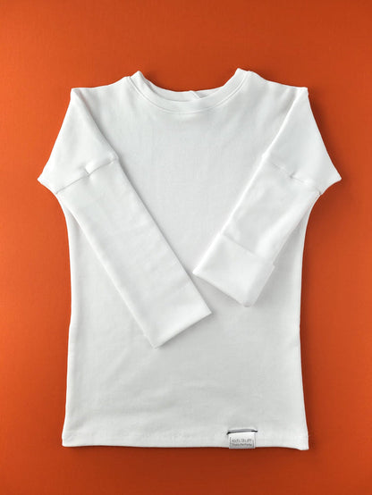 White grow-with-me shirt for toddlers and kids, designed to be worn as a dress, tunic, or long shirt. Seamless shoulders and soft, eco-friendly fabric. Ethically made in Canada.